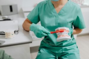 Photo of a Dentist Demonstrating How to Brush Teeth