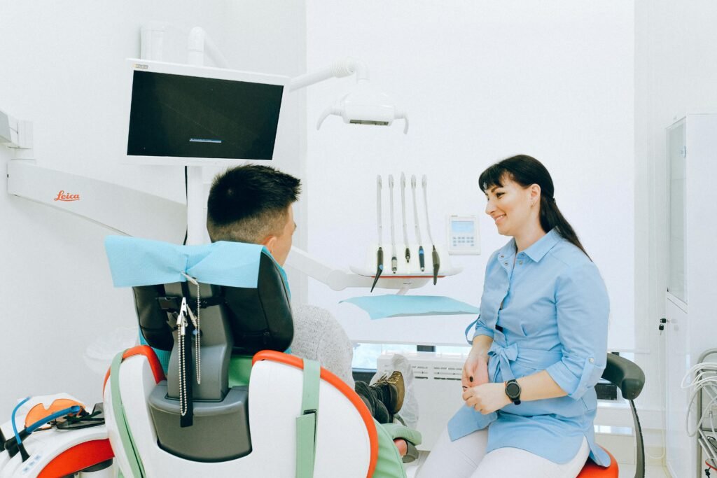 Dentist interacting with patient in a bright, modern dental clinic.